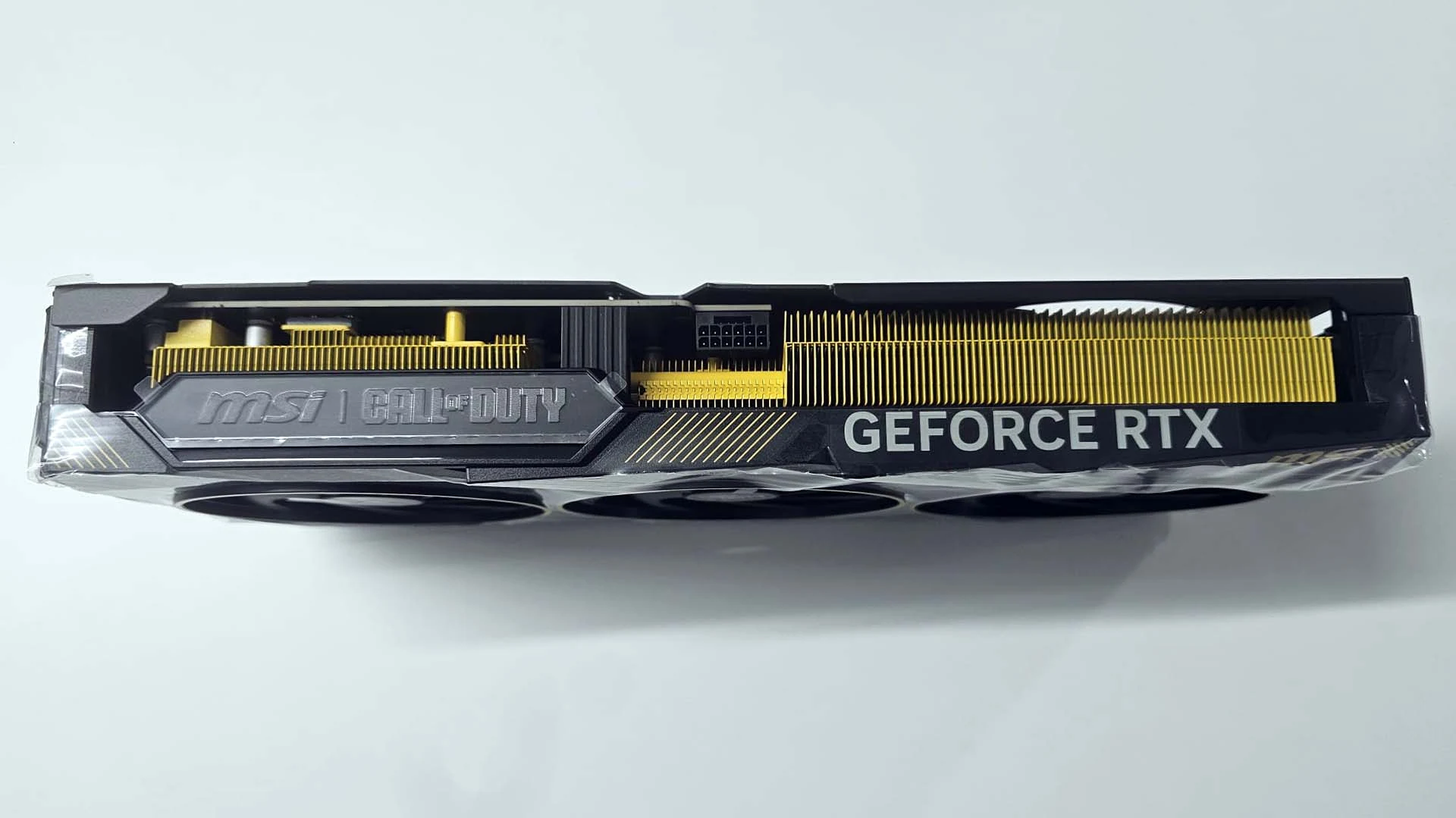 Lateral da MSI RTX 5080 COD MW4 Edition com as alhetas do dissipador pintadas de amarelo