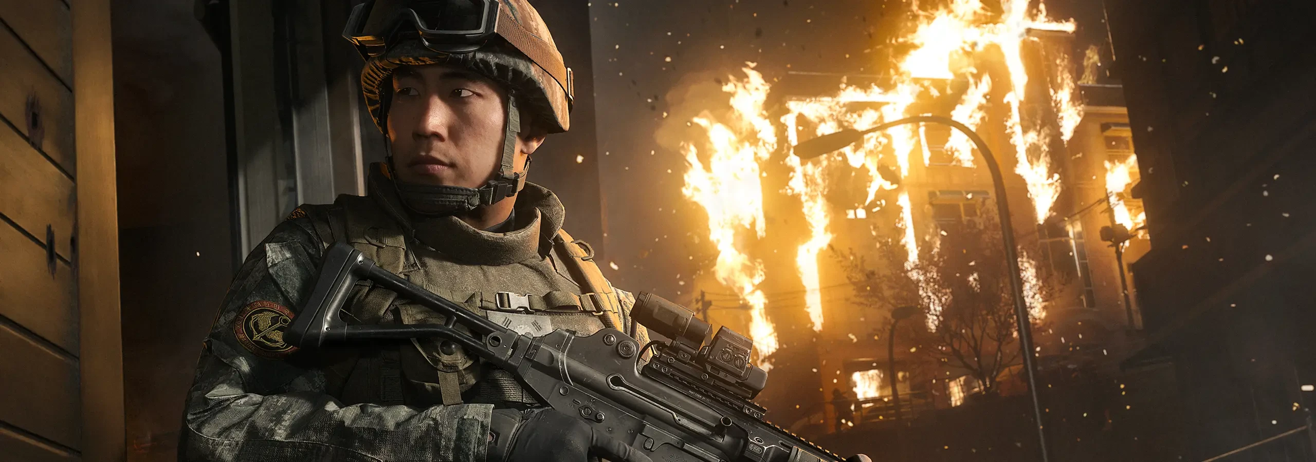 Um soldado sul-coreano de arma em punho junto a uma casa em chamas na campanha de Modern Warfare 4