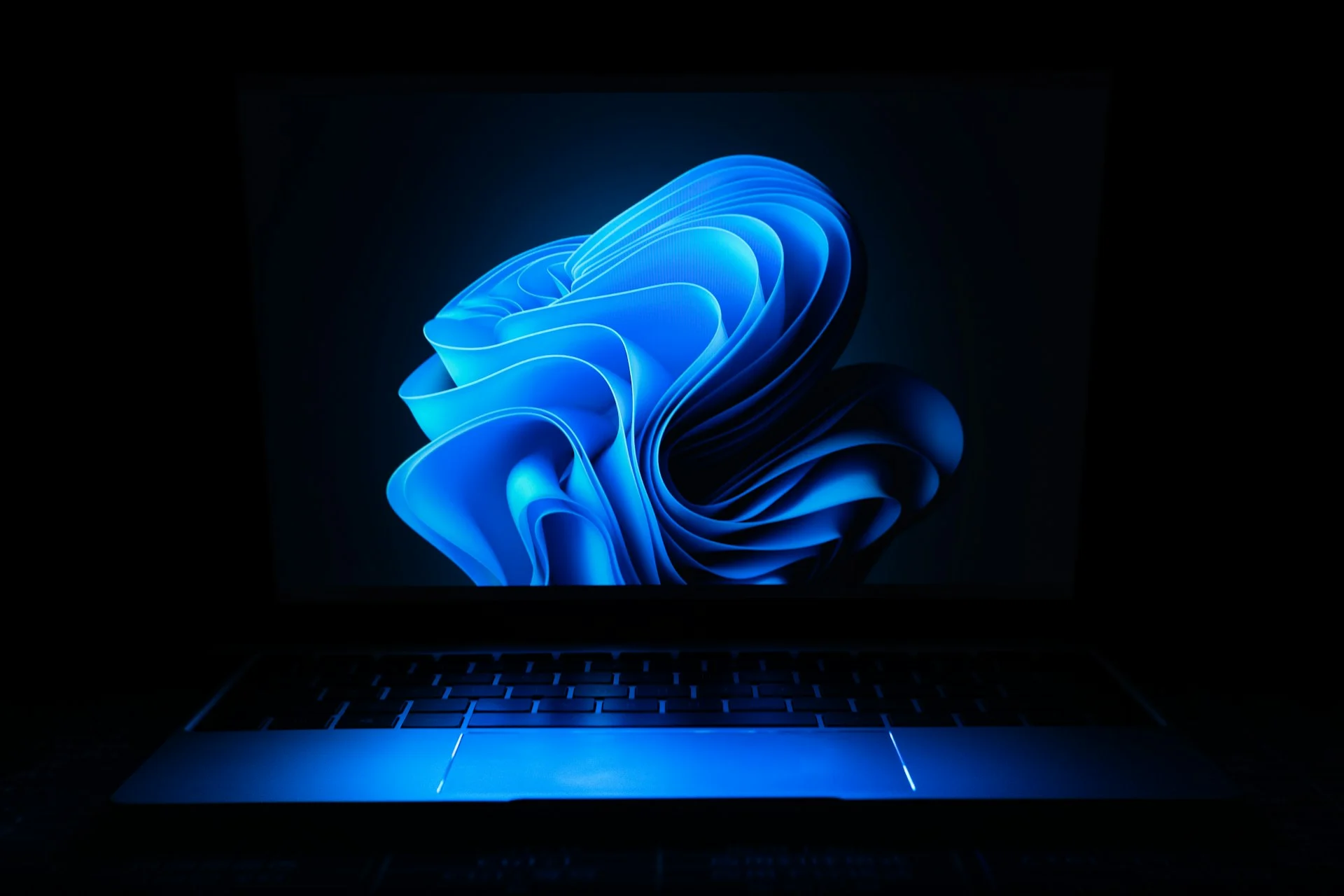 Um portátil com Windows 11 aberto numa sala escura